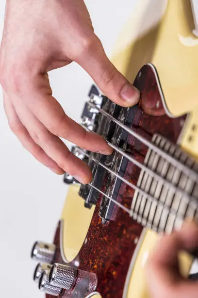 detail of male hand playing bass guitar