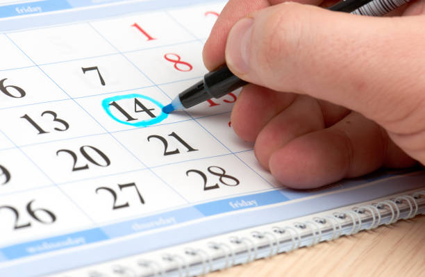istock Hand marks date in the calendar in blue 641544600