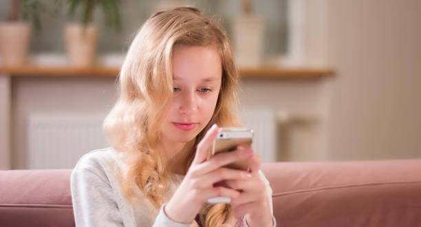 istock Blonde young girl focus on smartphone screen 641548238