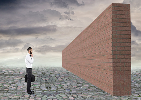Thoughtful businessman looking at wall, end of the road concept