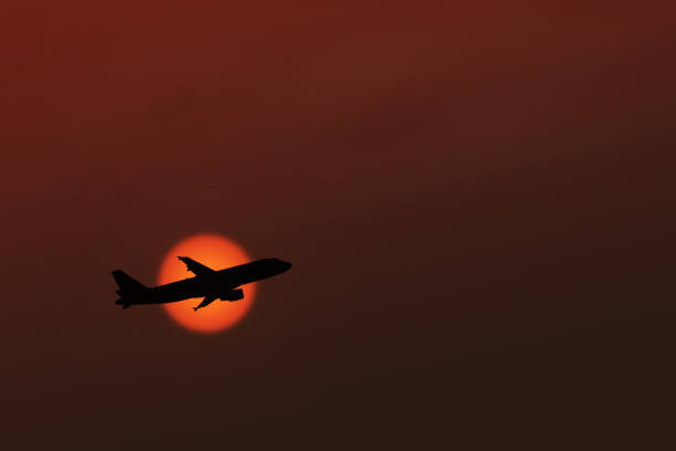 istock Silhouette of an airplane taking off on sunset background 641563094