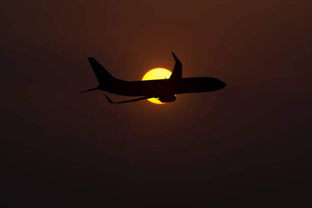 istock Silhouette of an airplane taking off on sunset background 641563096