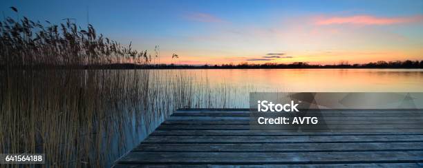 Wooden Dock On Calm Lake At Sunset Stock Photo - Download Image Now - Boardwalk, Jetty, Lake