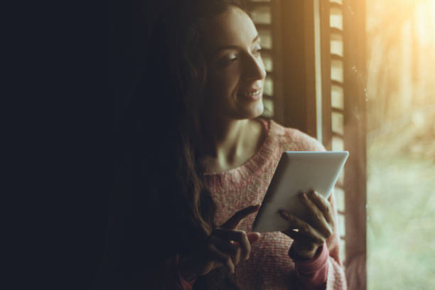 istock Happy woman reading tablet and having coffee in the kitchen 641564688