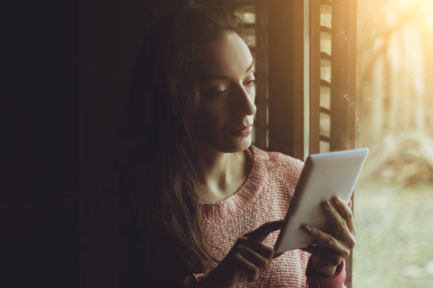 istock Beautiful woman using a tablet in a bright room 641567270