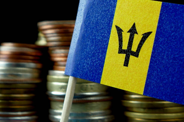 istock Barbados flag waving with stack of money coins macro 641568138