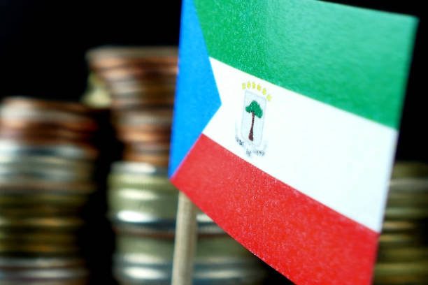 istock Equatorial Guinea flag waving with stack of money coins macro 641568282