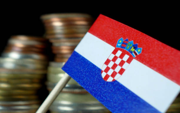 istock Croatian flag waving with stack of money coins macro 641568930