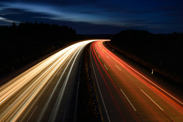 Long Exposure of Car Lights on Winding Motorway at Night Winding Motorway, long exposure of Car Lights at Dusk autobahn stock pictures, royalty-free photos & images