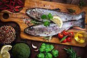 Two raw trout on dark slate background