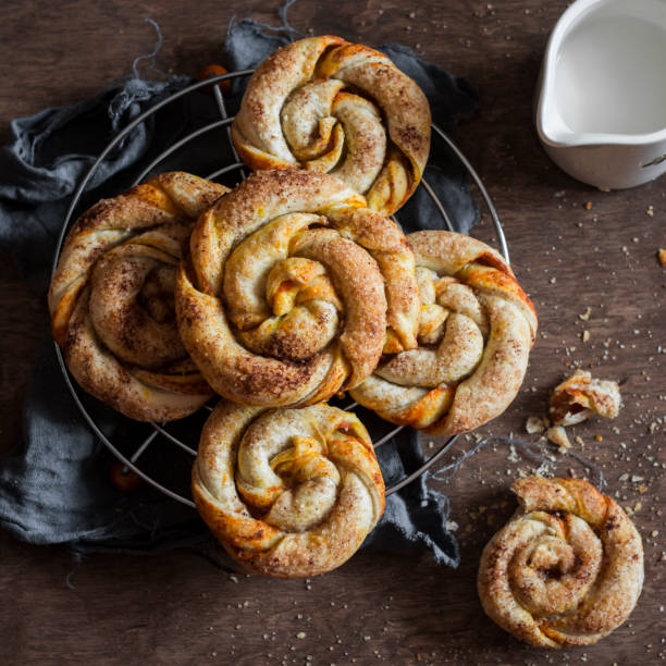 istock Pumpkin cinnamon buns on a wooden board, top view 641570612