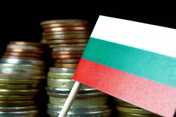 Bulgarian flag waving with stack of money coins macro