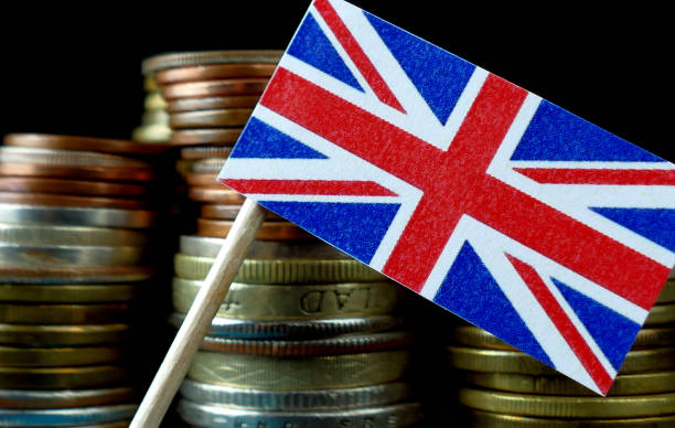 grã-bretanha bandeira acenando com uma pilha de dinheiro moedas macro - british flag currency banking uk - fotografias e filmes do acervo
