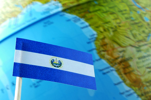 El Salvador flag with a globe map as a background macro