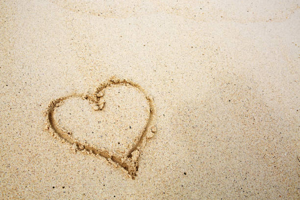 istock Hearts drawn on the sand of a beach 641573024