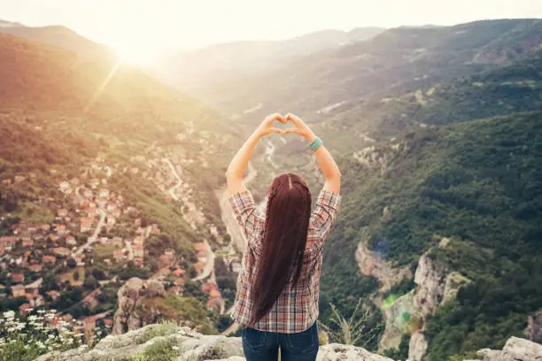 Photo of Young woman showing heart-shaped symbol