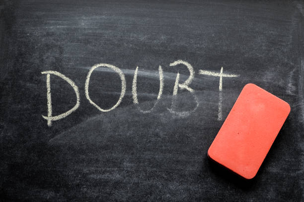 istock erasing doubt, hand written word on blackboard being erased concept 641577044