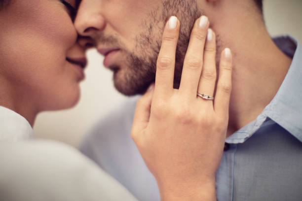 Lovely couple kissing outdoors. They are young and beautiful and they are realy enjoying in their love. She has an engagement ring on her hand