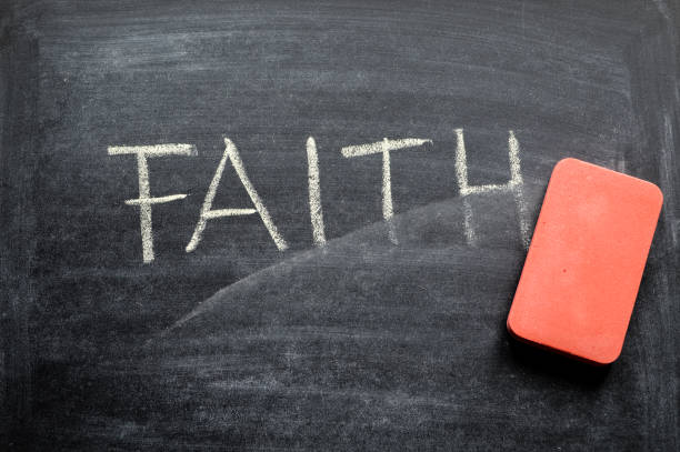 istock erasing faith, hand written word on blackboard being erased concept 641577496