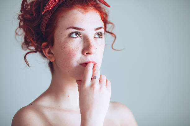 Beautiful young redhead woman thinking