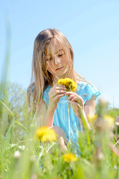 istock girl with dandelions 641582208