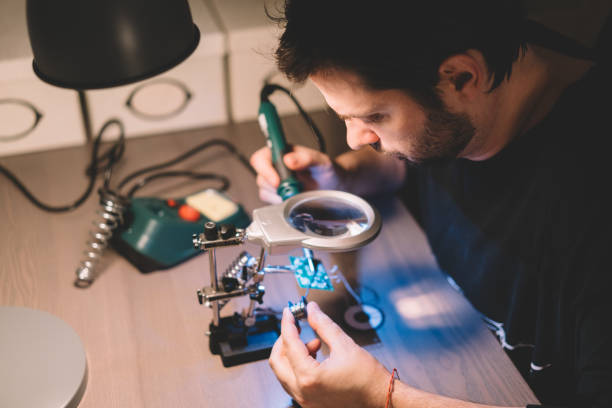 maison bricolage - male magnifying glass caucasian technician photos et images de collection