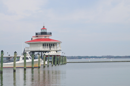 The historic Choptank Lighthouse with a recreational boat at anchor and a lifeboat stowed on davits.