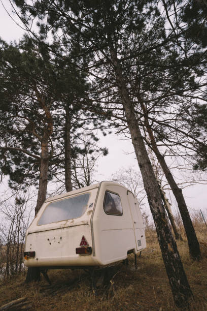istock Old rusty camper parked in the woods. Low angle view. 641588856
