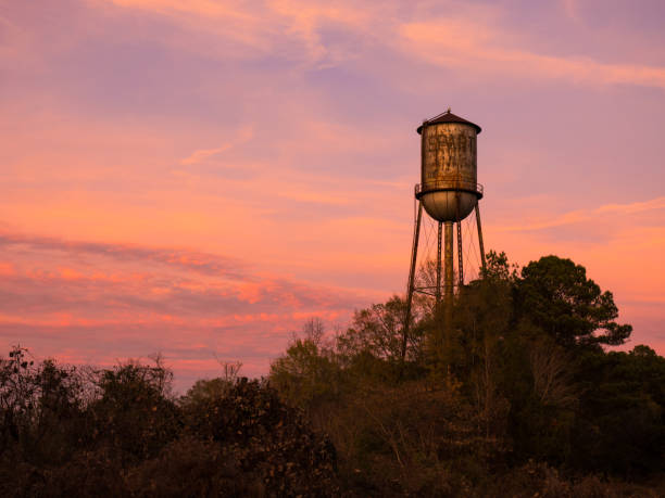 Old Small Town Water Tower Against Brilliant Sunset Sky