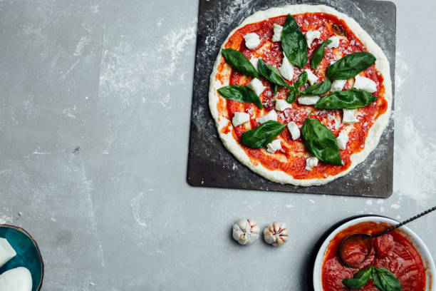 istock Overhed view of uncooked pizza on a baking sheet 641603522