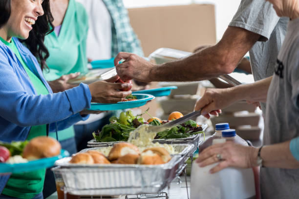 istock Volunteers serve people in soup kitchen 641609394
