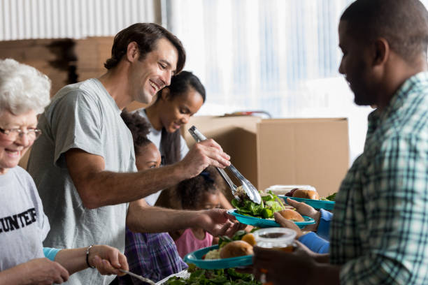 istock Cheerful Caucasian man serves healthy meal in soup kitchen 641609430