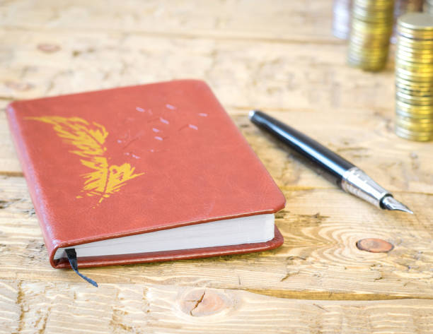 istock Fountain pen,calculator, coins and notebook on a wooden table. 641610880