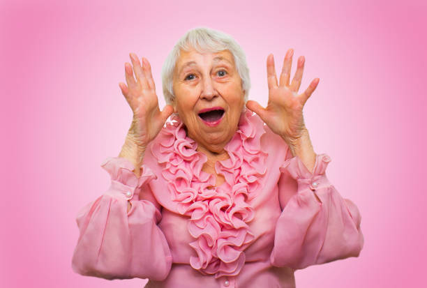 Elderly surprised woman screaming on rose studio background