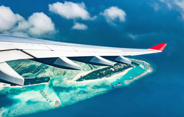istock Airplane flying over blue sea and island window view 641615344