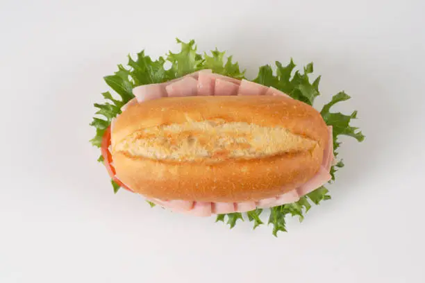 crusty roll sandwich with ham on white background