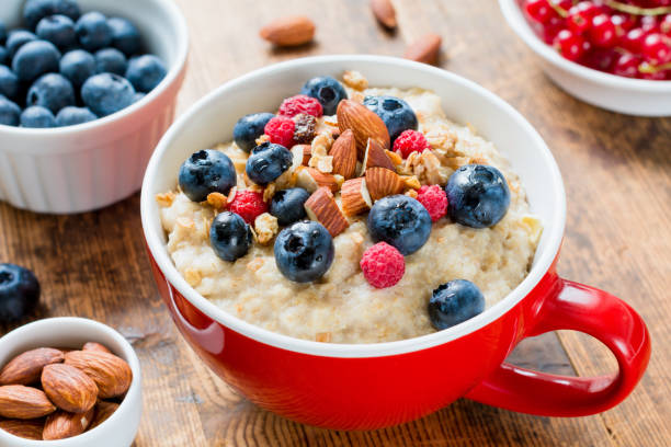 Oatmeal porridge with blueberries, raspberries and almonds stock photo