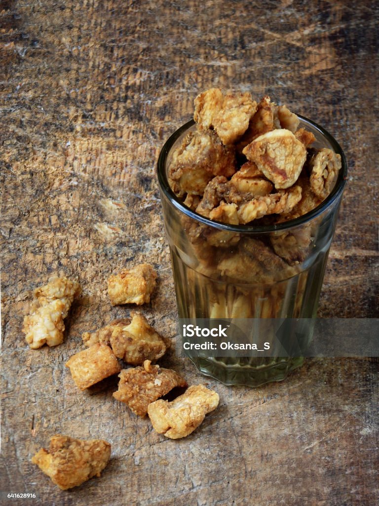 Homemade pork crackling, scratchings, various fried bacon Homemade pork crackling, scratchings, various fried bacon in glass on wooden background. selective focus Bacon Stock Photo