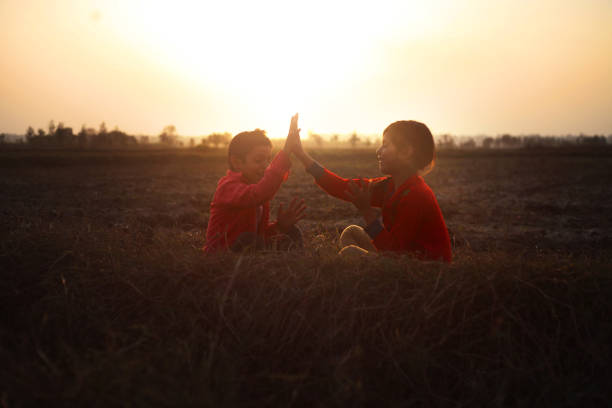 Two children playing in the nature outdoor in dusky day.