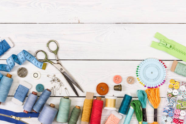 Tools and accessories for sewing on light wooden background. Tools and accessories for sewing on light wooden background. Top view. thread sewing item stock pictures, royalty-free photos & images