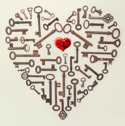 Key close up and red hearts on a natural wooden background. Valentine's Day