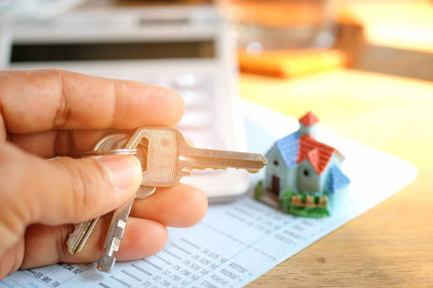 istock Key in hand with house model and  calculator. 641642512