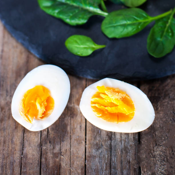 istock Salad with green spinach baby leaves and boiled eggs cut in a half  on rustic wooden table. 641645480