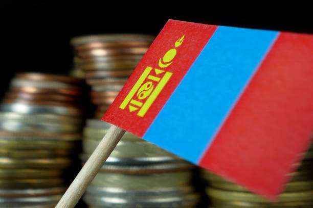 istock Mongolia flag waving with stack of money coins macro 641646152