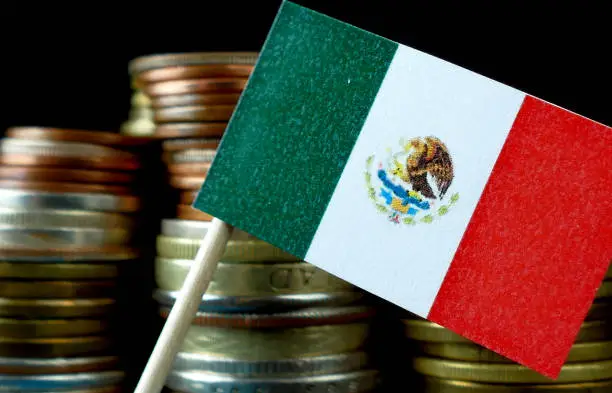 Mexico flag waving with stack of money coins macro