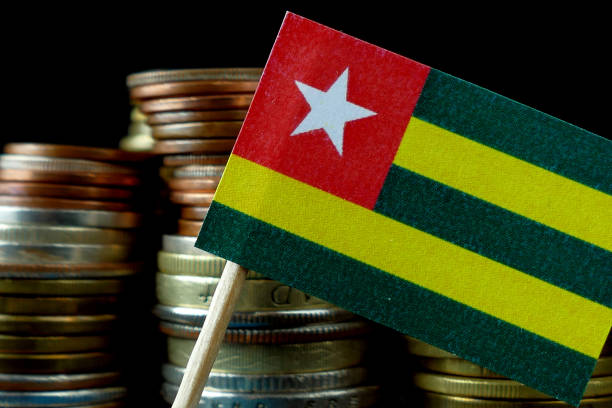 istock Togo flag waving with stack of money coins macro 641646964