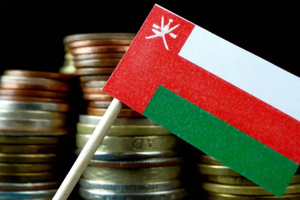 Oman flag waving with stack of money coins macro