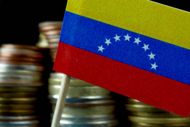istock Venezuela flag waving with stack of money coins macro 641649294