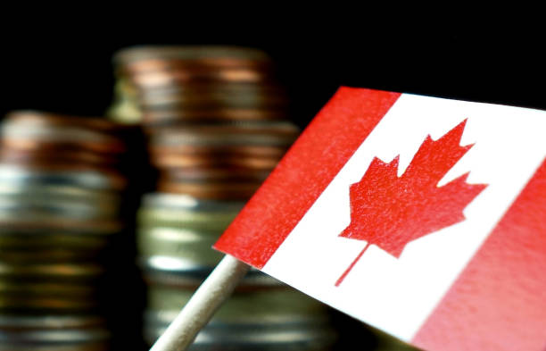 Canada flag waving with stack of money coins macro Canada flag waving with stack of money coins macro cent sign photos stock pictures, royalty-free photos & images