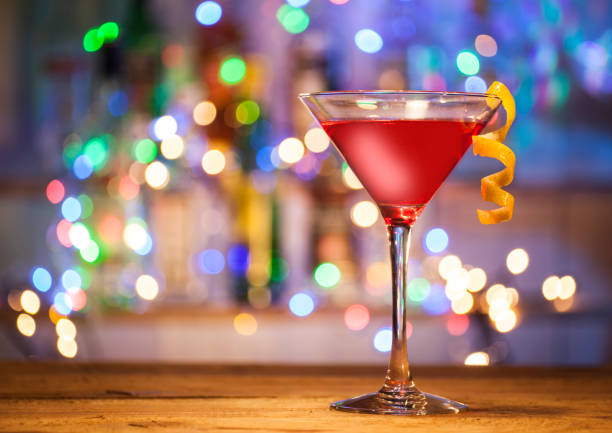 bicchieri di cocktail cosmopolita su uno sfondo di luci da bar. - cocktail transparent cocktail shaker glass foto e immagini stock